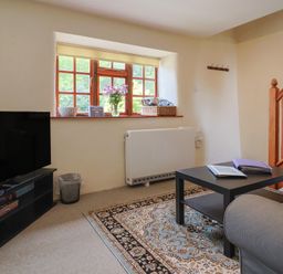 A living room with a television and a coffee table at Jasmine Cottage South Perrott near Mosterton