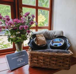 A basket with towels and bowls near a guest book at Jasmine Cottage in South Perrott near Mosterton