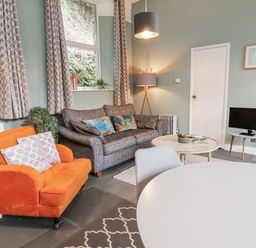 A living room with a sofa, armchair, and coffee table at Ferndale in Lynton