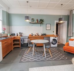 A kitchen with appliances and a dining table at Ferndale in Lynton