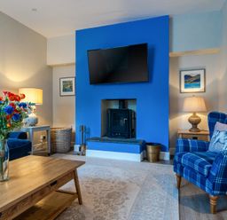 A living room with a sofa and television at Home Farmhouse at the Graythwaite Estate near Hawkshead