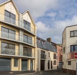 A street view with modern and traditional buildings and a no entry traffic sign at Harbourside Haven Penthouse 1 in Weymouth