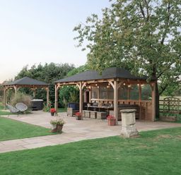 A garden with a gazebo, outdoor furniture, and planters at Reybridge House in Lacock