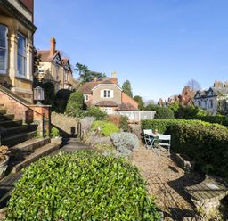 An outdoor garden area with stone steps and green bushes with a small table and two chairs at The Escape in Malvern
