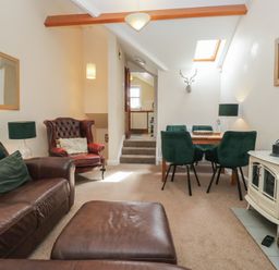 A living room with a sofa and dining area at Walkers Retreat Keswick
