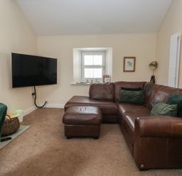 A living room with a sofa and television at Walkers Retreat in Keswick