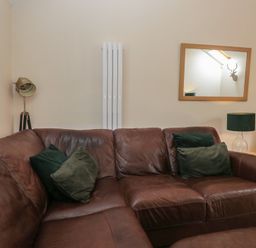 A living room with a brown sofa and decorative items at Walkers Retreat in Keswick
