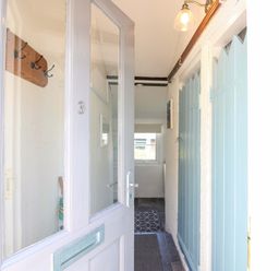 A hallway with hooks and a light fixture at 3 Rock Cottages Kingston