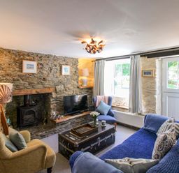 A living room with a fireplace and television at 3 Rock Cottages in Kingston
