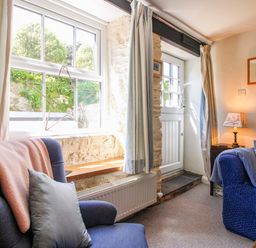 A living room with an armchair and a sofa at 3 Rock Cottages in Kingston