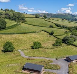 A view of fields and trees at Birch Banc Retreats - Bedw Llanidloes