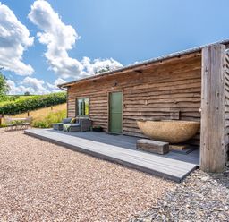 An outdoor view of a wooden building with a deck at Birch Banc Retreats - Bedw Llanidloes