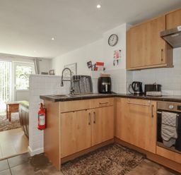 A kitchen with wooden cabinets and appliances at 49 Atlantic Reach in Newquay