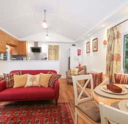 A living room with a dining area and kitchen in Orchard Lodge Bolney