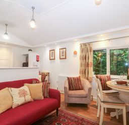 A living room with furniture and a dining area at Orchard Lodge Bolney