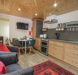 A kitchen with a stove, oven, and dining table at Harvest Lodge in Wineham near Bolney