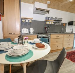 A kitchen with a dining table set for meals at Harvest Lodge Wineham near Bolney