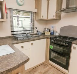 A kitchen with a stove microwave sink and countertop at 12A Borwick Lakes in South Lakeland Leisure Village