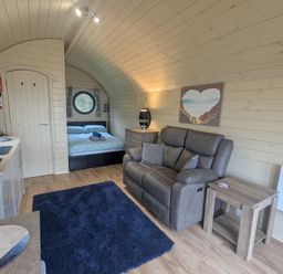 A studio with a sofa, kitchenette, and bed at Stapeley Pod White Grit near Chirbury