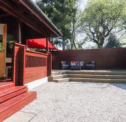 An outdoor patio area with wooden steps and decking with chairs and a table at Gisburn Forest Lodge in Tosside near Wigglesworth