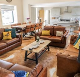 A living room with brown leather sofas and a wooden dining table at Pheasant's Roost in Lelley near Burton Pidsea