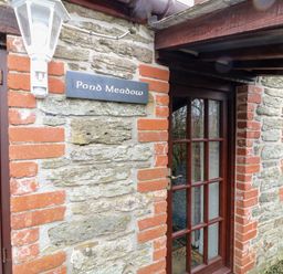 Exterior view of a stone and brick building with glass panel door and windows at Pond Meadow Warbstow