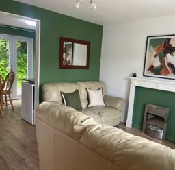 A living room with a sofa and fireplace at Eirlys in Caeathro near Caernarfon
