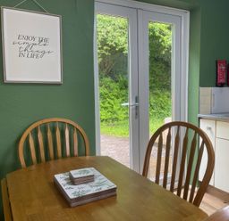 A kitchen with a table and chairs at Eirlys in Caeathro near Caernarfon