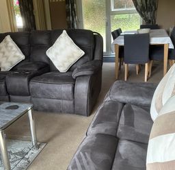 A living room with a sofa and dining area at Watergate Bay in Liskeard