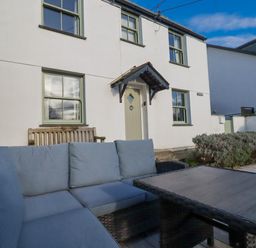 An outdoor area with a seating arrangement and a house at Tresawle in Crantock