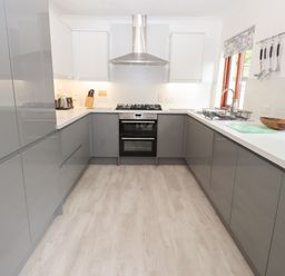 A kitchen with grey cabinets and gas stove at Fir Trees in Bowness-On-Windermere