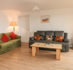 A living room with two sofas a wooden coffee table floor lamp and side table with lamp at The Outlook in Crowcombe