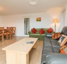 A living room with two sofas a coffee table wooden dining table and chairs at The Outlook in Crowcombe