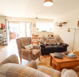 A living room with armchairs a sofa a wooden coffee table and dining table at Varley Villa in Newtown