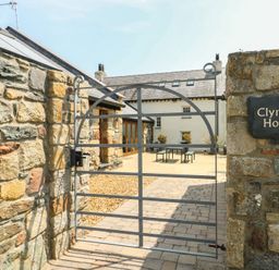 A gated entryway with a stone wall at Clynnog House in Dwyran near Newborough