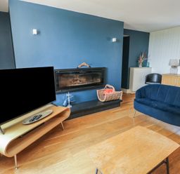 A living room featuring a television and a fireplace at Clynnog House Dwyran near Newborough