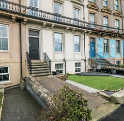 Row of terraced houses with steps leading to front doors and small front gardens in Whitby