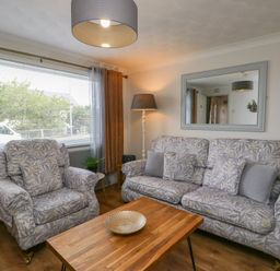 A living room with a sofa and armchair at Glasfryn in Holyhead