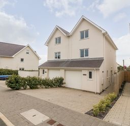 Two attached modern beige houses with garages and paved driveways in a residential area at 3 Lon Y Dryw in Trearddur Bay