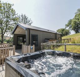 An outdoor area with a hot tub and wooden deck at Hares Rest in Nantmel near Rhayader