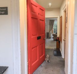 A hallway with a red door and a dog toy at Red Screes Cottage in Ambleside