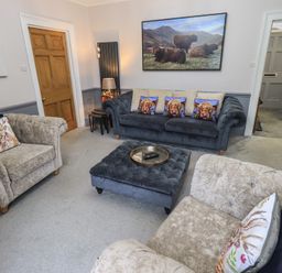 A living room with two sofas, a coffee table and a painting at Red Screes in Ambleside
