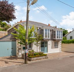 A house with blue doors and windows and a small garden bed in front at Armando in Devoran Cornwall