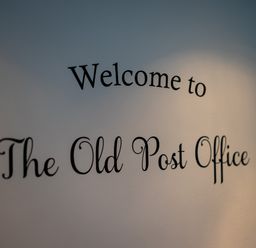 A wall with the words Welcome to The Old Post Office