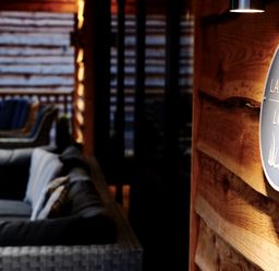 An outdoor seating area with sofas and chairs with a wooden wall and a sign that says Lake View Lodge at Lake View Lodge in Thorpe-On-The-Hill