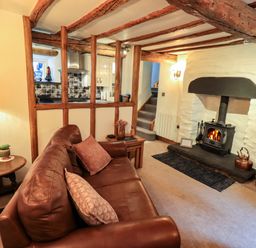 A living room with a sofa and fireplace at Fellside Cottage Bowness-On-Windermere