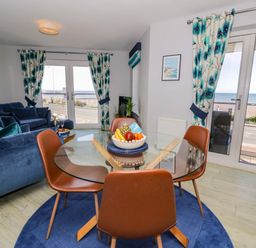 A living room with a table and chairs at Ocean View Apartment in Colwyn Bay