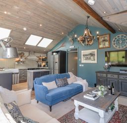 An open plan living room and kitchen with sofas and a wooden coffee table at The Owls Shack in Kendal