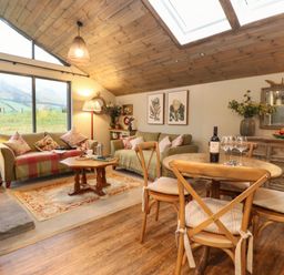 A living room with two sofas a wooden coffee table and a dining table with four chairs at The Badger's Shack in Garnett Bridge Longsleddale Near Kendal