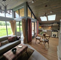 A living room with a sofa and dining area at The Hare's Shack in Garnett Bridge, Longsleddale. Near Kendal